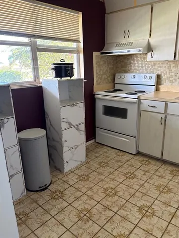 a kitchen with cabinets and window
