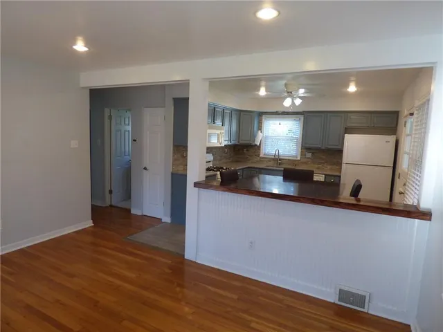 a kitchen with granite countertop a refrigerator and a sink