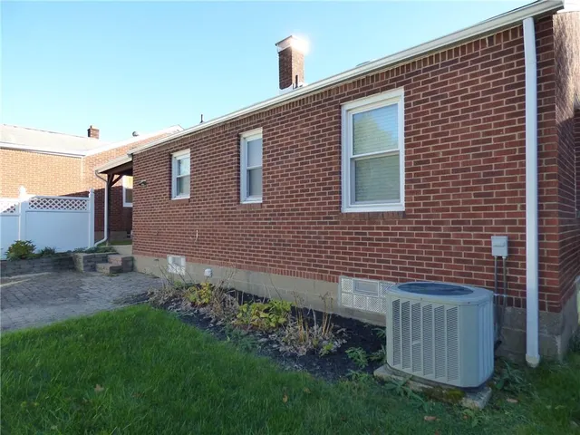 a brick house with a small yard and plants