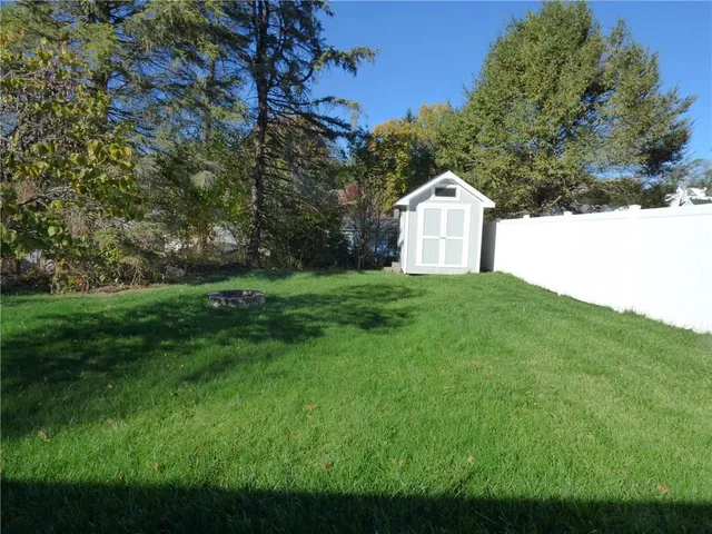 a white house with a big yard and large trees