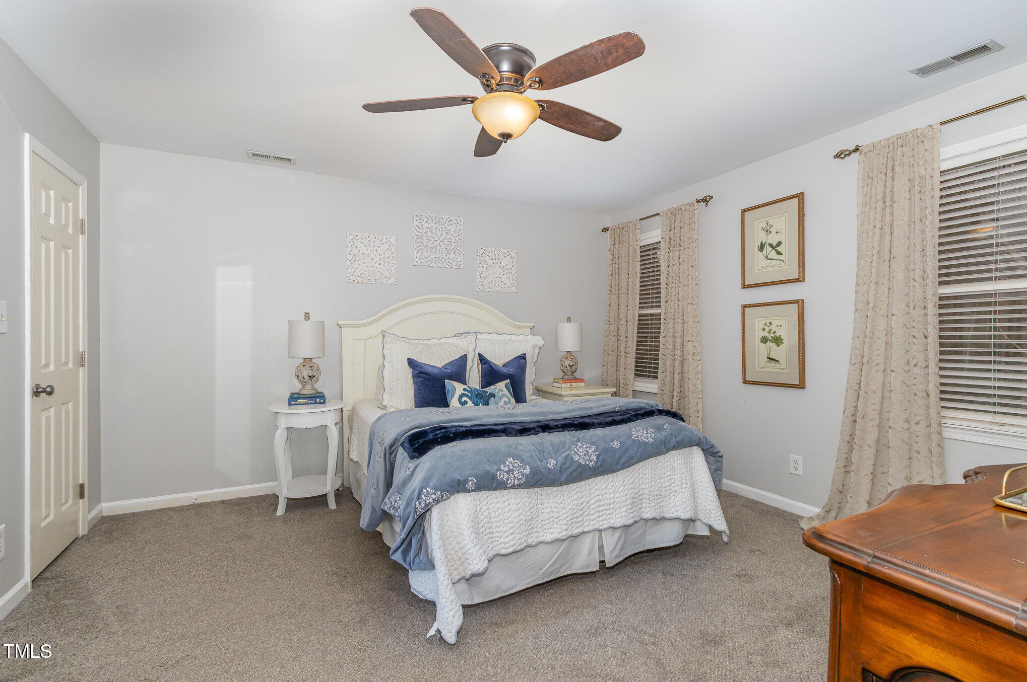 401 Rosehaven Drive Raleigh, NC 27609 - Photo 14 of 26 Two windows, a ceiling fan, and a walk-in closet make this primary bedroom a comfortable retreat.