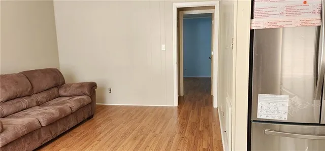 a living room with furniture and a refrigerator