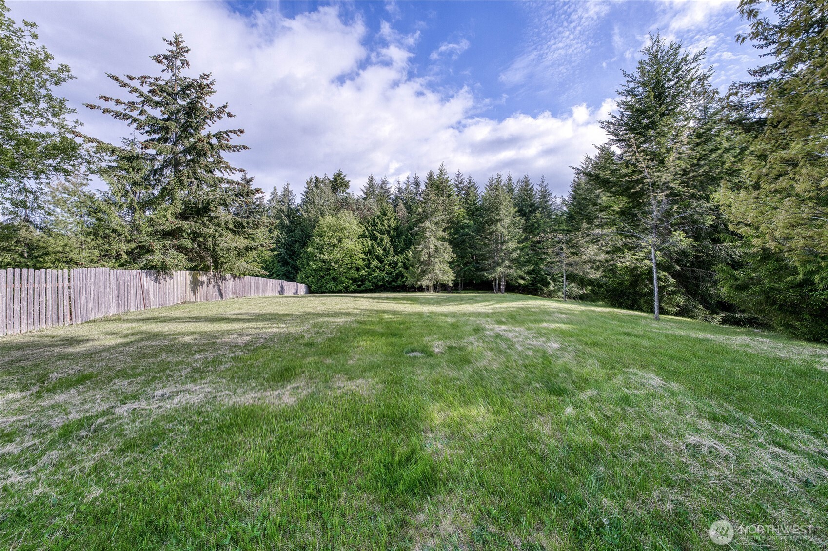 a view of a field with trees in the background