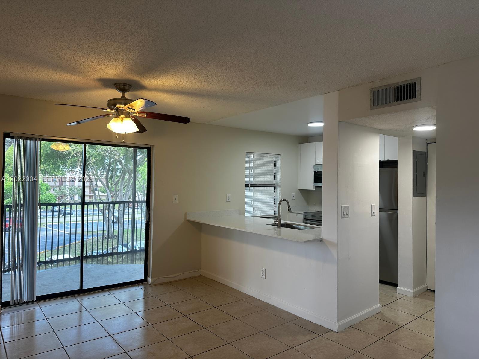 3400 Foxcroft Road, Unit 301 Miramar, FL 33025 - Photo 35 of 72 a kitchen with stainless steel appliances kitchen island granite countertop a refrigerator and a sink