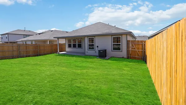 a front view of a house with a yard and green space