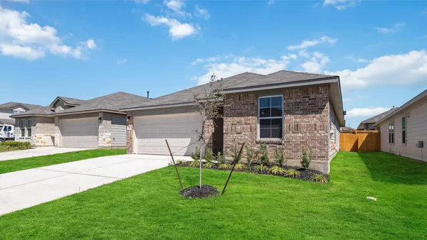 a brick house with a small yard and front view of a house