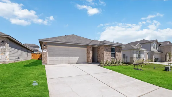 a front view of a house with a garden and yard