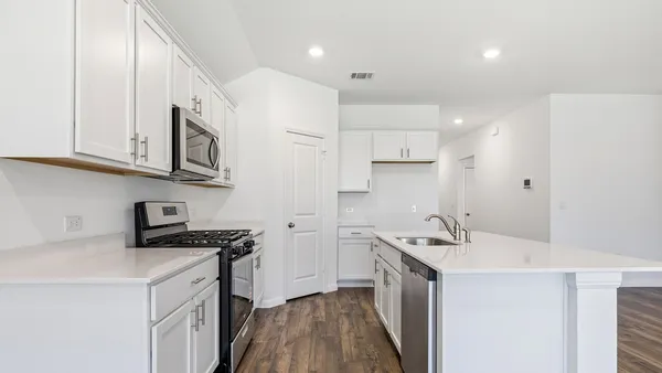 a kitchen with a sink a stove and cabinets
