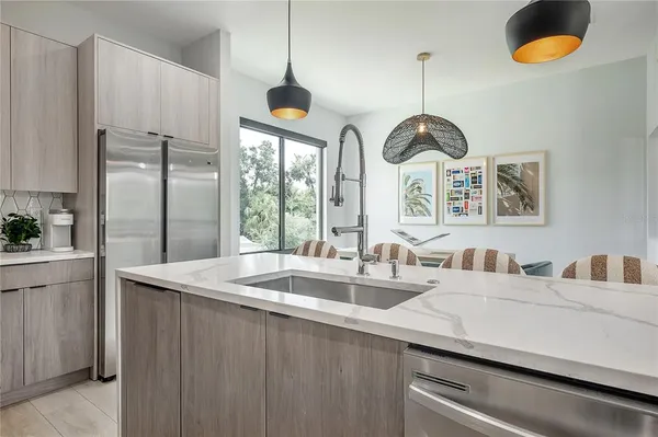 a kitchen with stainless steel appliances a sink a chandelier and refrigerator