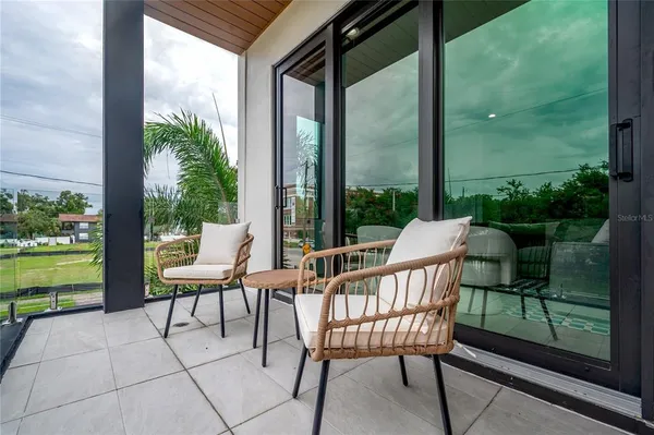 a view of a chair and tables in the balcony