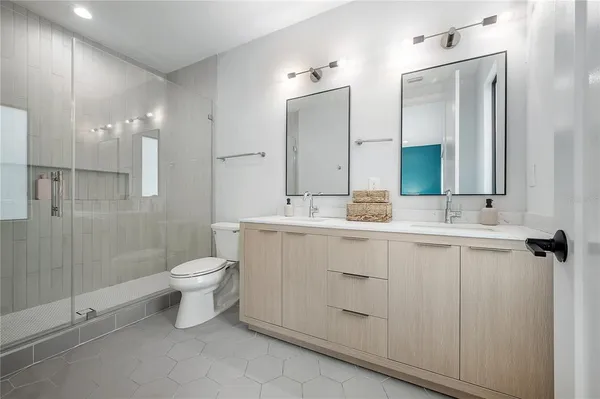 a bathroom with a double vanity sink a toilet and a mirror