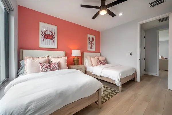 a bedroom with two beds and painting on the wall