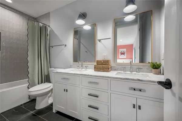 a bathroom with a double vanity sink toilet mirror and bathtub