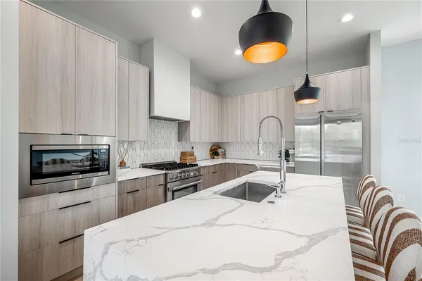 a kitchen with a appliances a sink a stove and cabinets