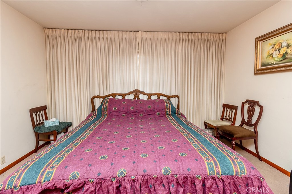 630 Acoma Street Needles, CA 92363 - Photo 16 of 60 a bed sitting in a bedroom next to a window with chair and couch
