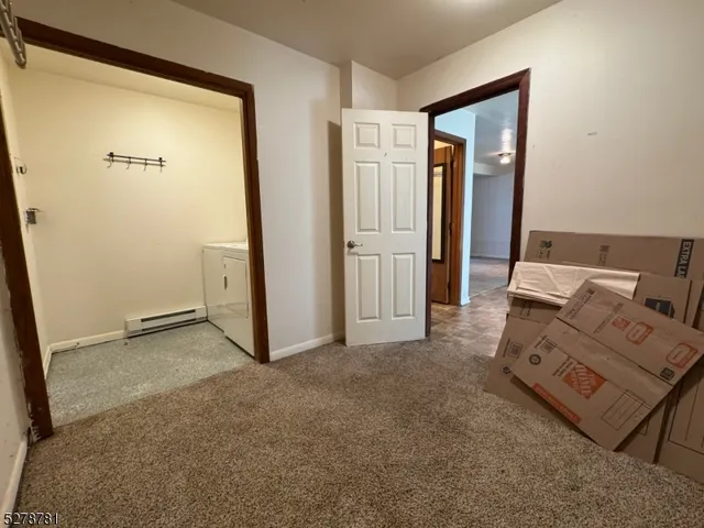an empty room with closet and a hallway