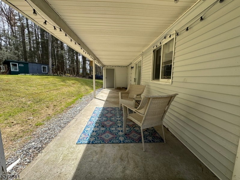 261 Old Chimney Ridge Road, Unit A Montague, NJ 07827 - Photo 35 of 43 a view of a patio with table and chairs with wooden floor and plants