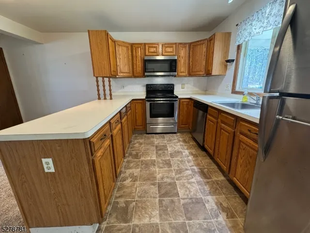 a view of kitchen with refrigerator and window