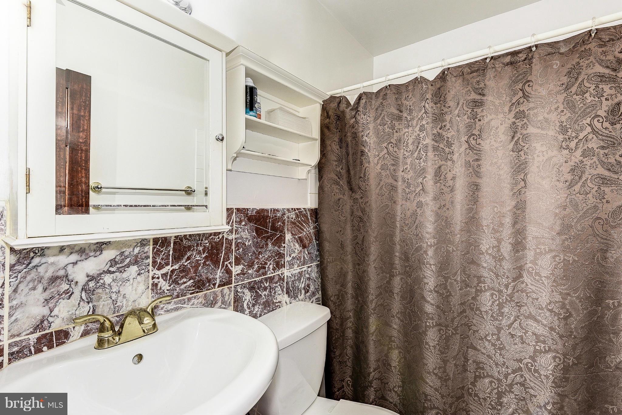 12301 Bluhill Road Silver Spring, MD 20902 - Photo 7 of 13 a bathroom with a sink and a mirror