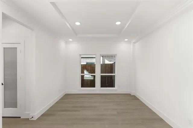 a view of empty room with wooden floor and window