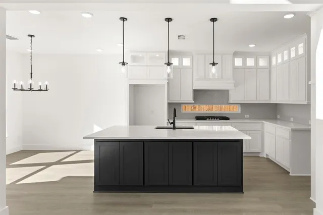 a kitchen with kitchen island a sink stainless steel appliances and cabinets