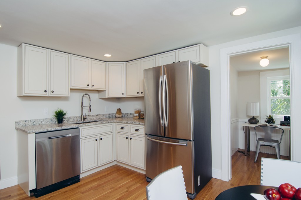 16 Port Norfolk Street, Unit 2 Boston, MA 02122 - Photo 4 of 13 a kitchen with stainless steel appliances a refrigerator sink and cabinets