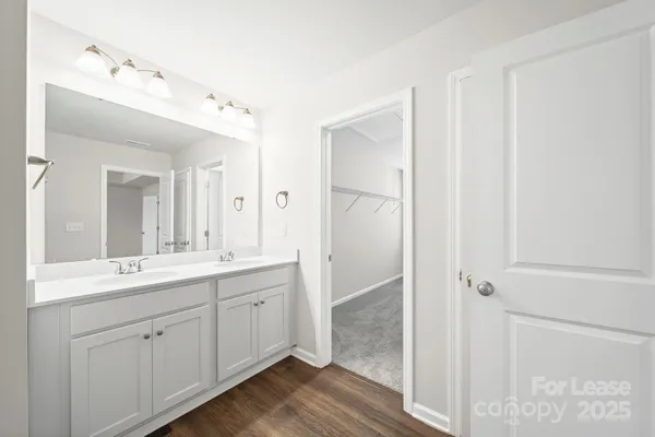 a spacious bathroom with a double vanity sink a mirror and shower