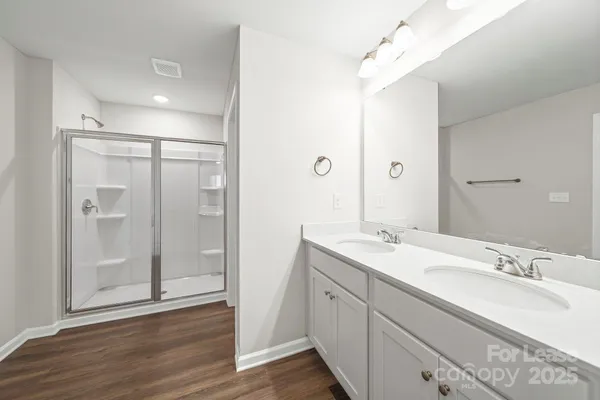 a bathroom with a shower sink vanity granite and mirror