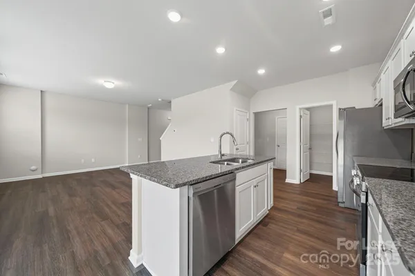 a kitchen with stainless steel appliances granite countertop a sink and stove top oven