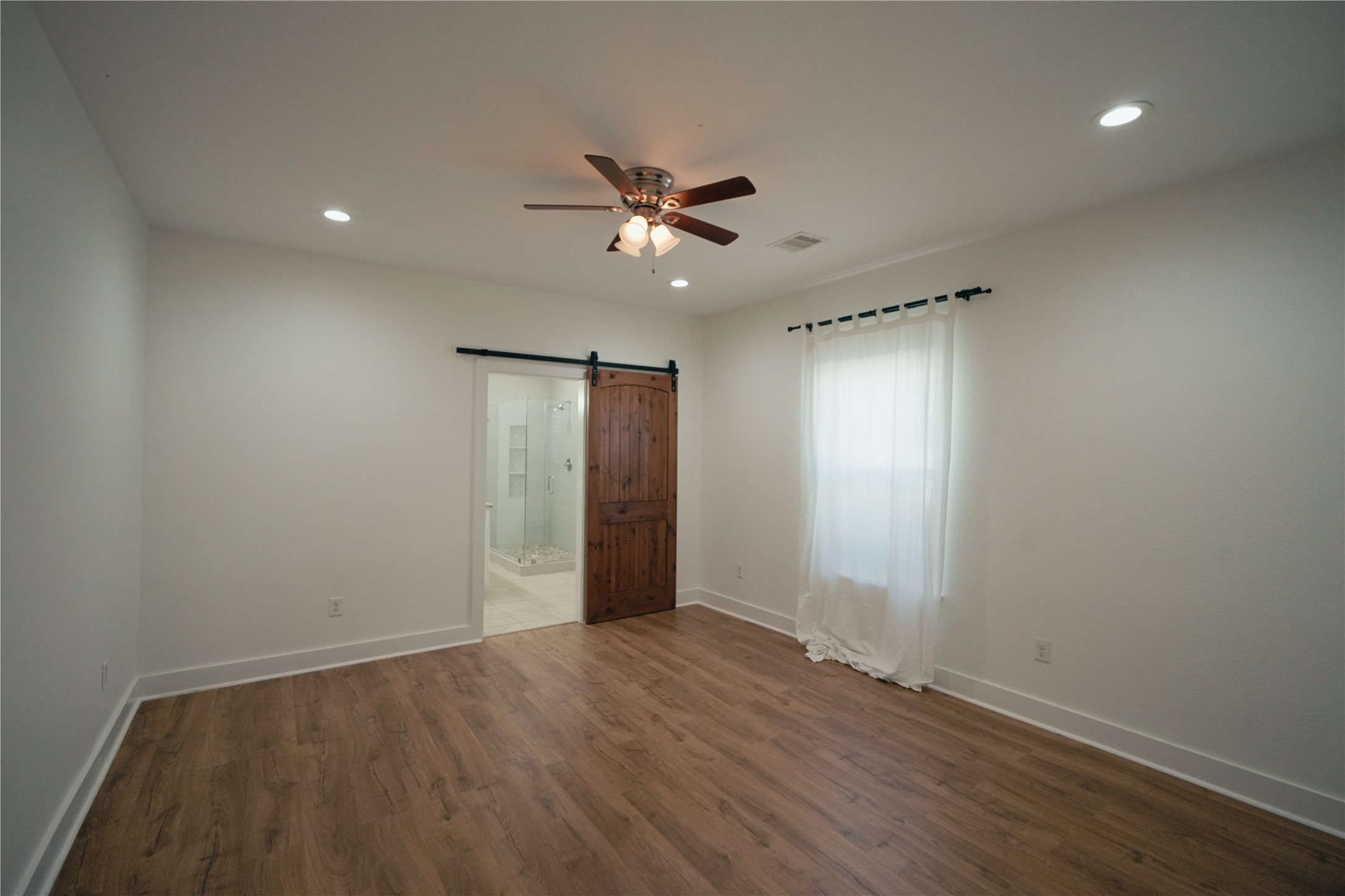 5105 Chapman Street Houston, TX 77009 - Photo 14 of 49 an empty room with wooden floor and windows