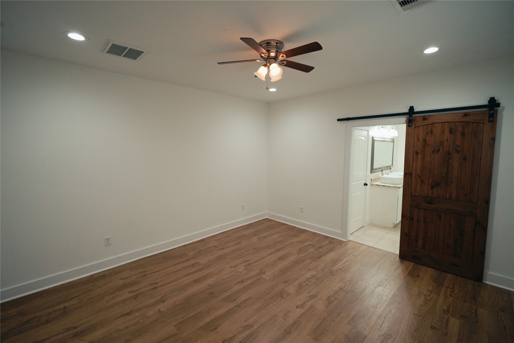 5105 Chapman Street Houston, TX 77009 - Photo 16 of 49 an empty room with wooden floor and a ceiling fan