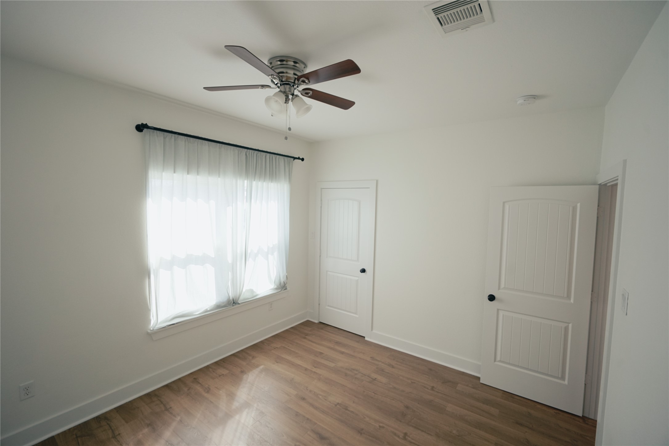 5105 Chapman Street Houston, TX 77009 - Photo 30 of 49 a view of an empty room with wooden floor and a window