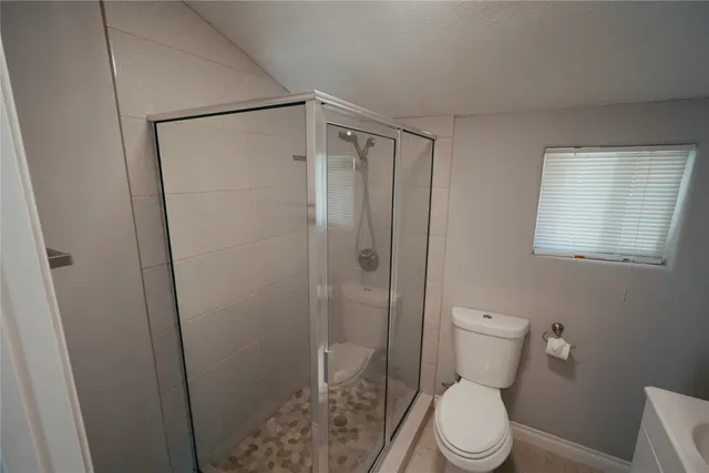 a white toilet sitting next to a shower