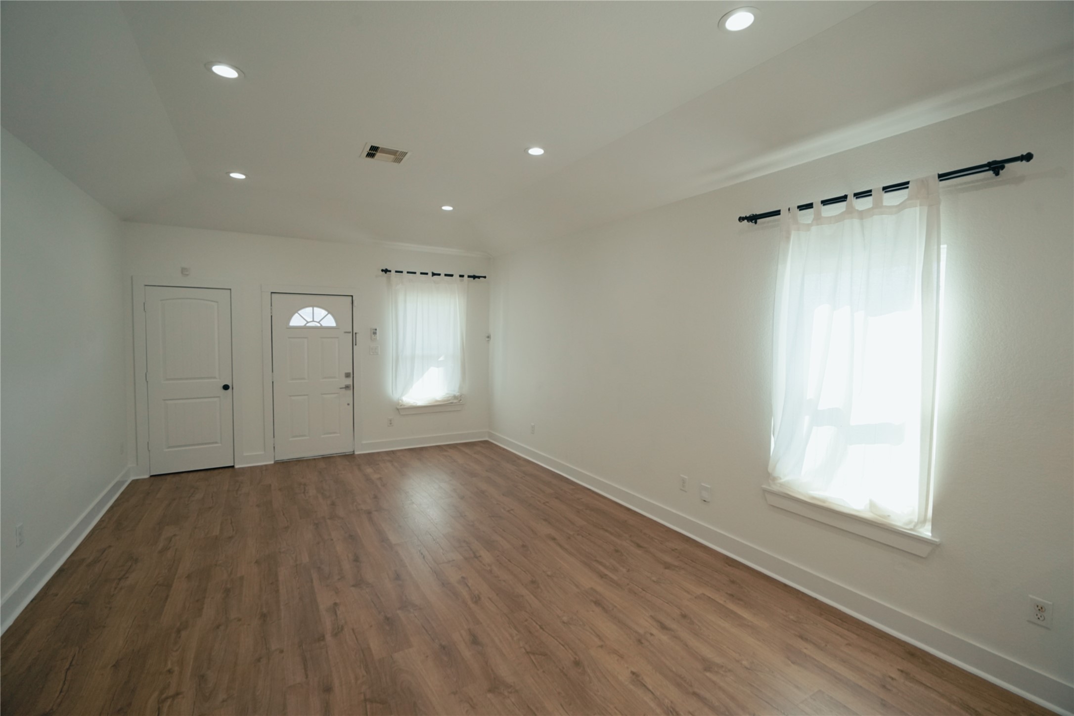 5105 Chapman Street Houston, TX 77009 - Photo 6 of 49 a view of an empty room with a window and wooden floor