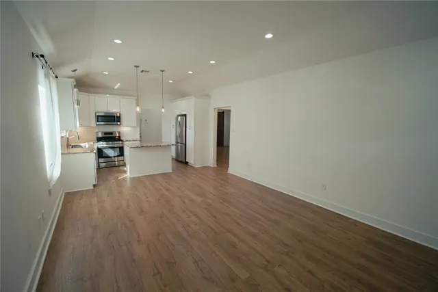 an empty room with wooden floor and a window