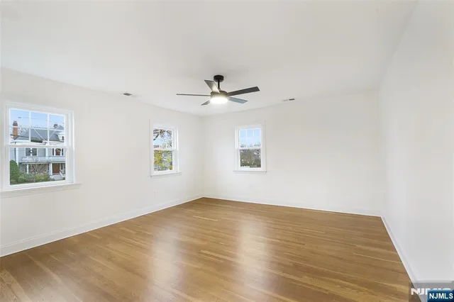a view of empty room with wooden floor