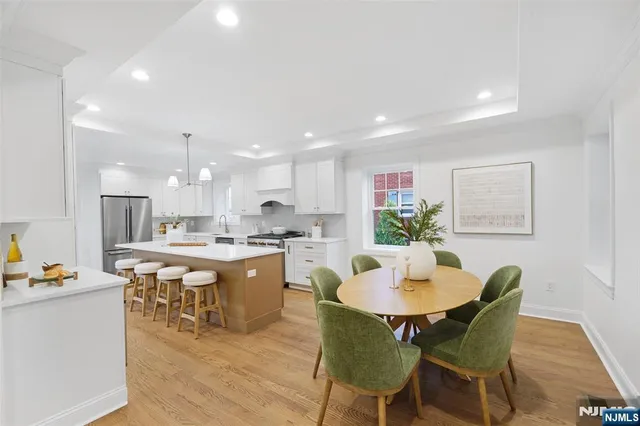 a kitchen with a dining table chairs and wooden floor