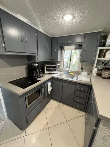 a kitchen with kitchen island a counter top space cabinets and stainless steel appliances