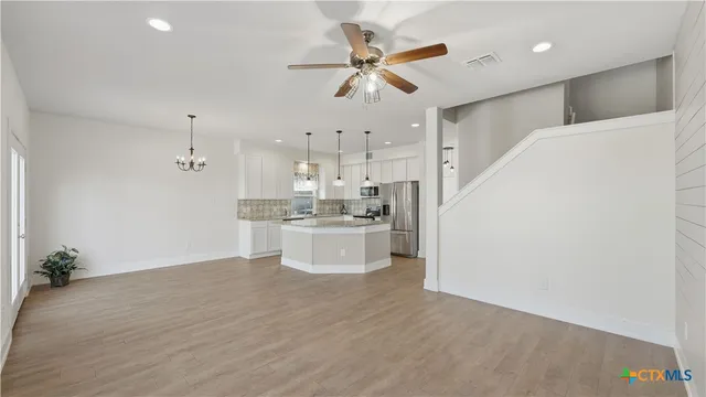 a view of kitchen with stainless steel appliances cabinets and a ceiling fan