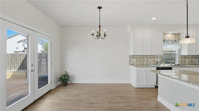 a view of a kitchen with a sink and dishwasher with wooden floor