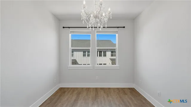 a view of empty room with window and wooden floor