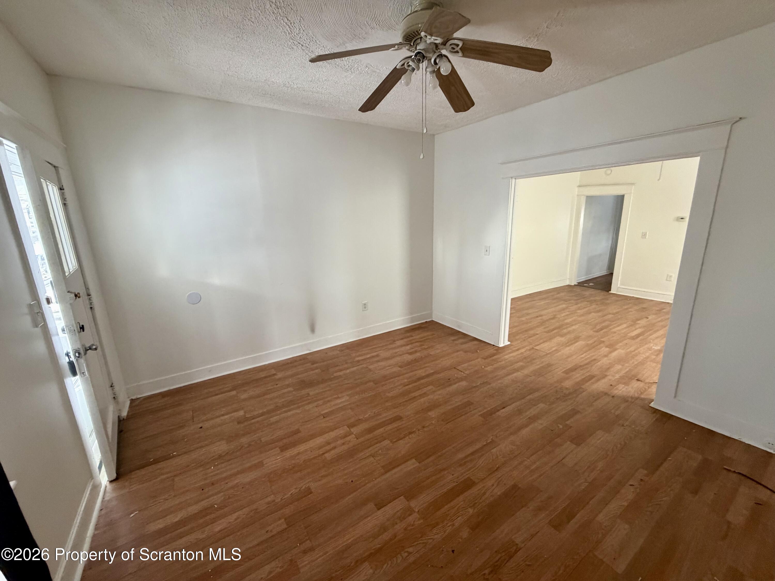 202 William Street Scranton, PA 18508 - Photo 2 of 11 an empty room with wooden floor and fan