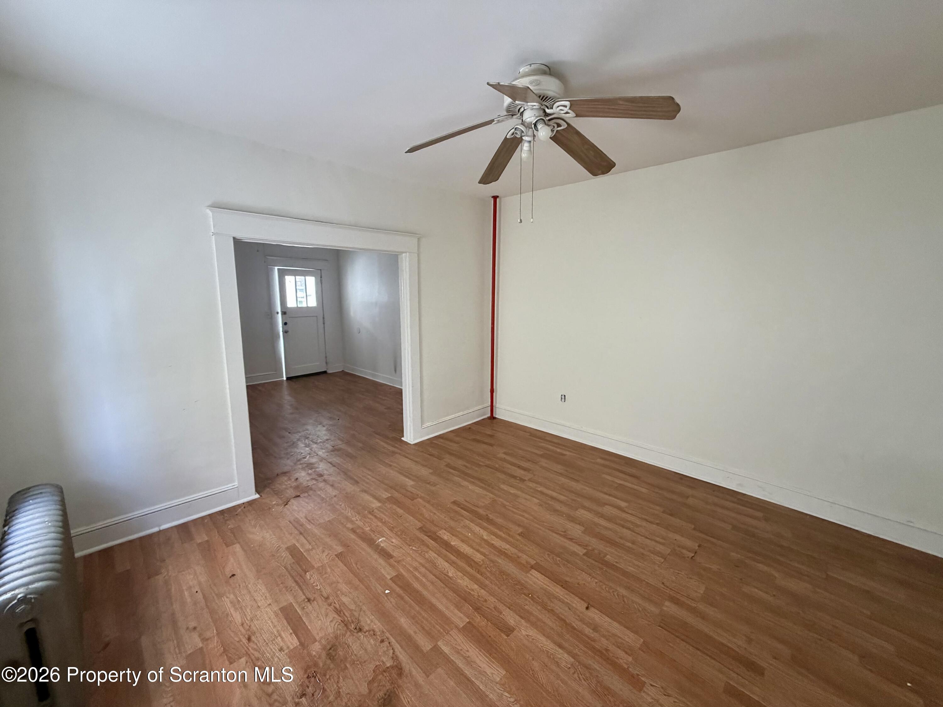 202 William Street Scranton, PA 18508 - Photo 5 of 11 a view of an empty room with a window and wooden floor