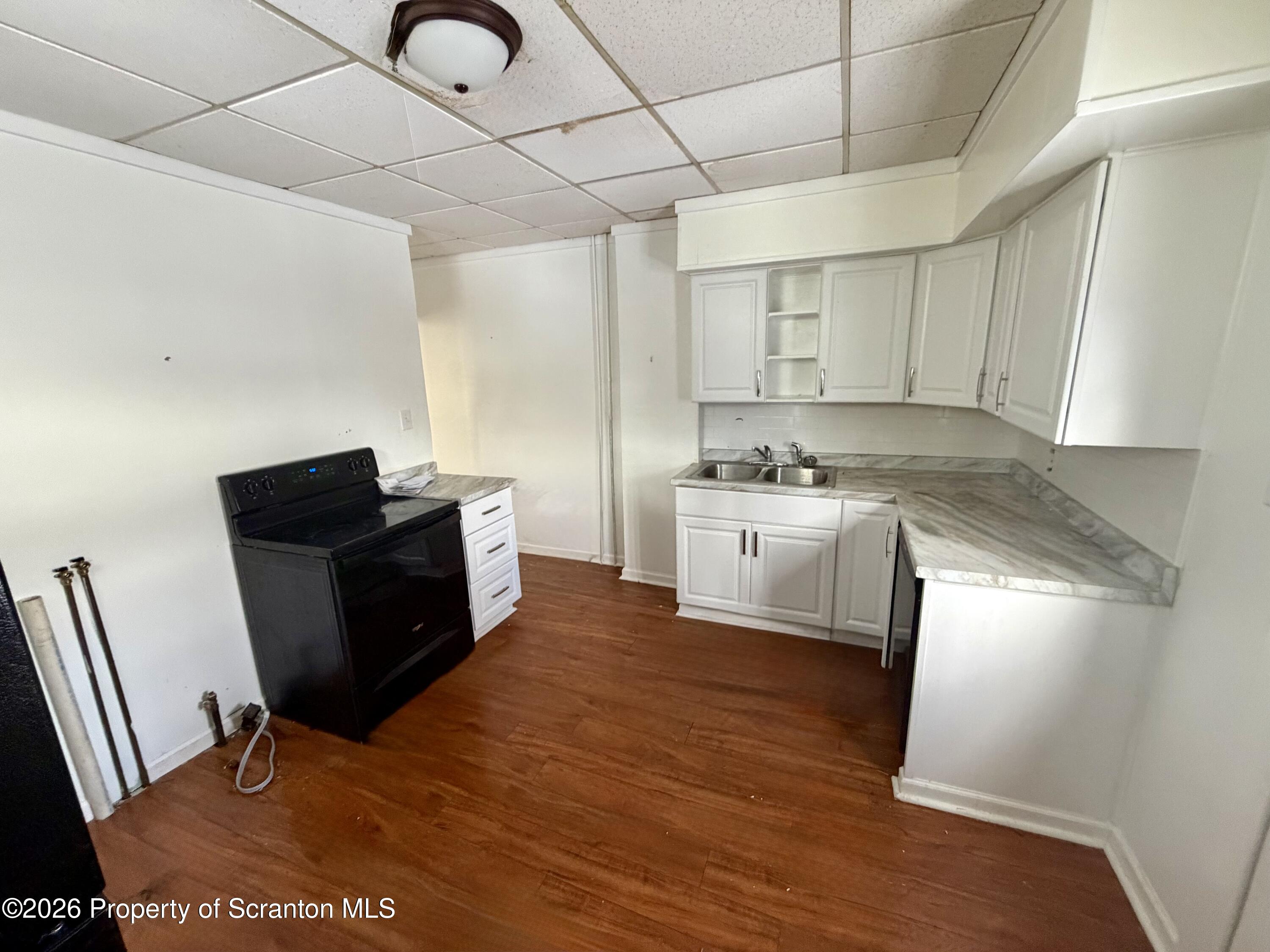 202 William Street Scranton, PA 18508 - Photo 6 of 11 a kitchen with stainless steel appliances granite countertop a sink dishwasher a refrigerator a stove with wooden floor