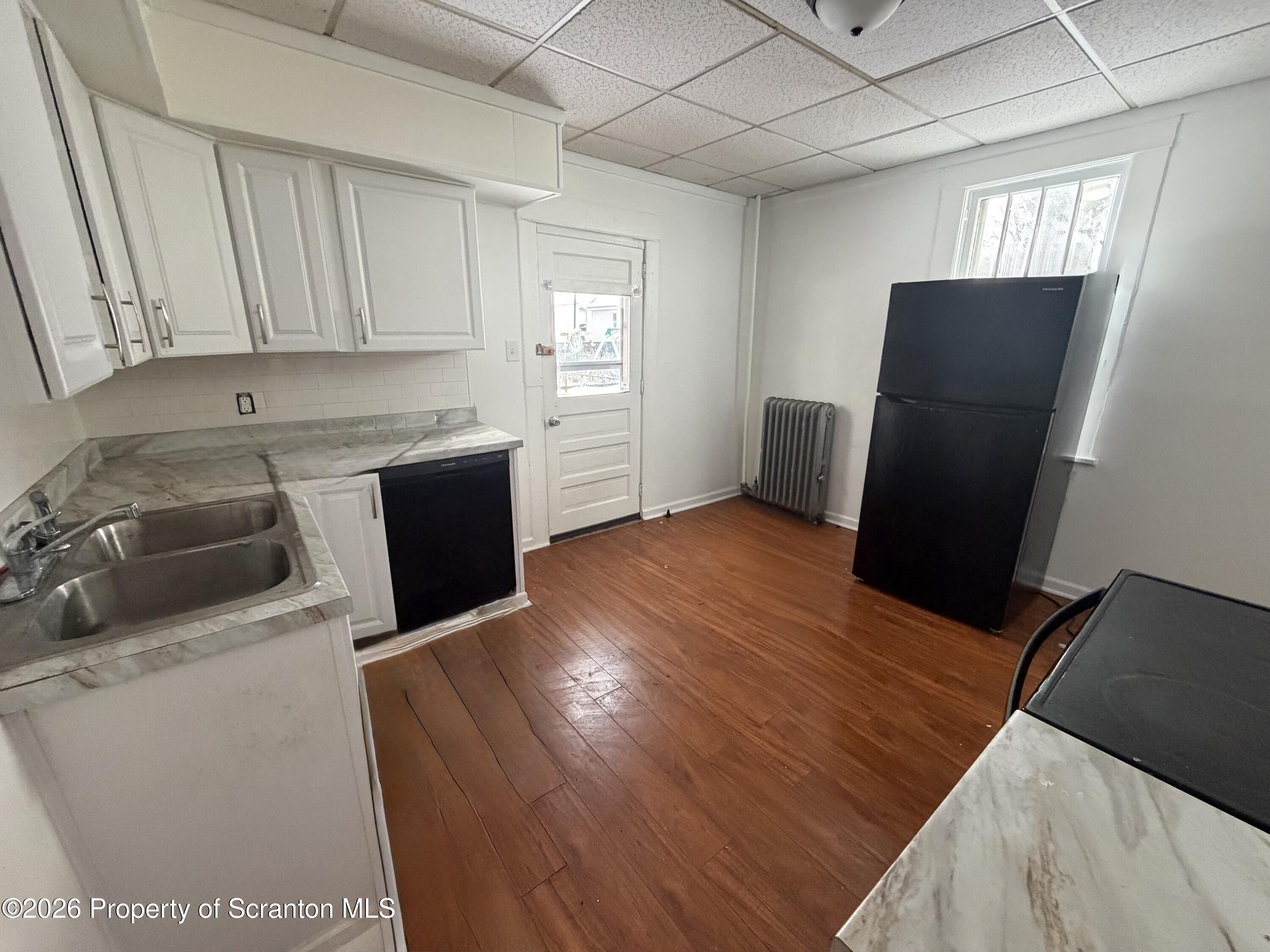 202 William Street Scranton, PA 18508 - Photo 7 of 11 a kitchen with a sink a refrigerator and window