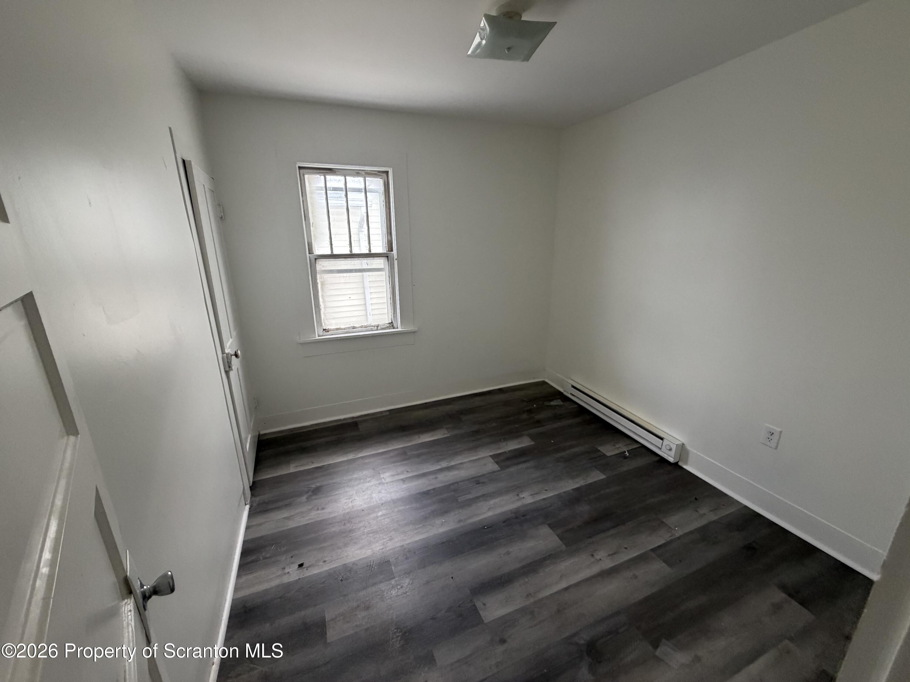202 William Street Scranton, PA 18508 - Photo 9 of 11 an empty room with wooden floor and windows