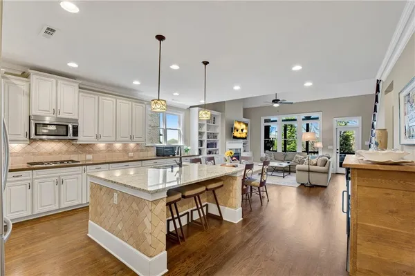 a kitchen with stainless steel appliances kitchen island granite countertop a stove a sink and a refrigerator