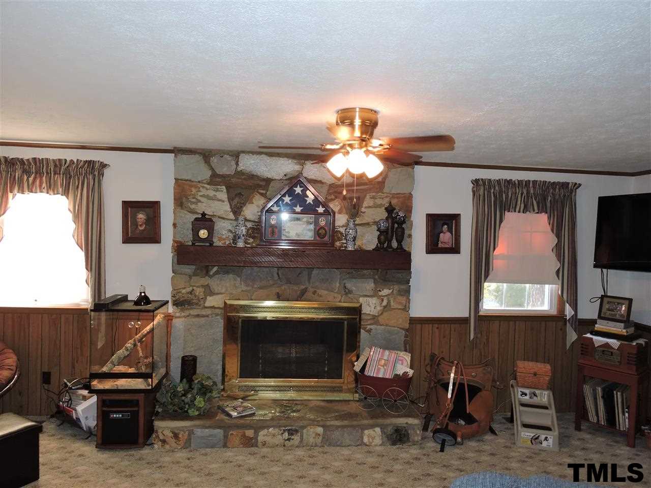 910 Antioch Church Road Timberlake, NC 27583 - Photo 4 of 22 a living room with furniture a flat screen tv and kitchen view