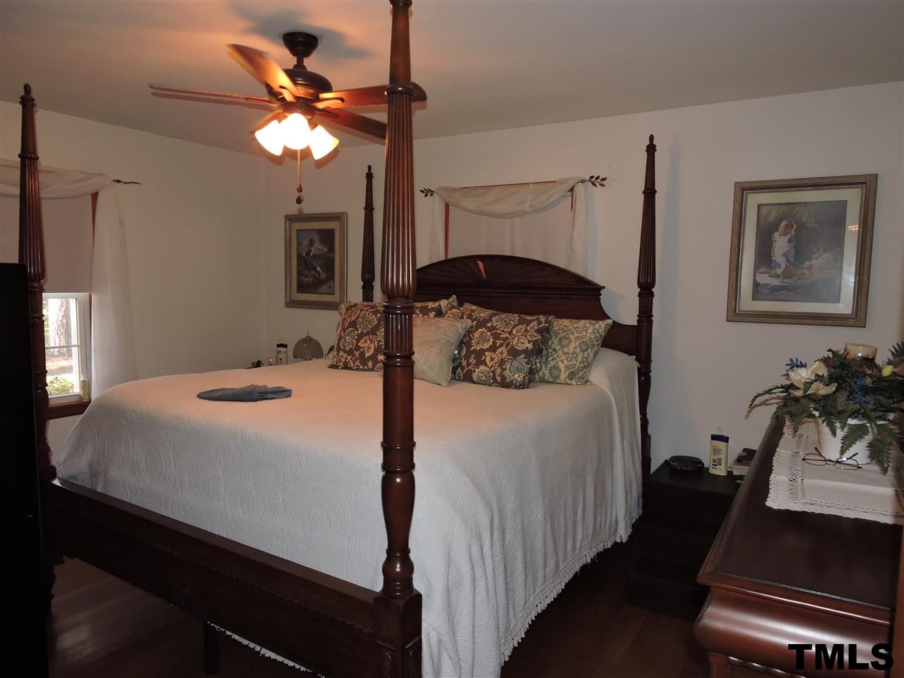 910 Antioch Church Road Timberlake, NC 27583 - Photo 7 of 22 a bedroom with a bed and a chandelier