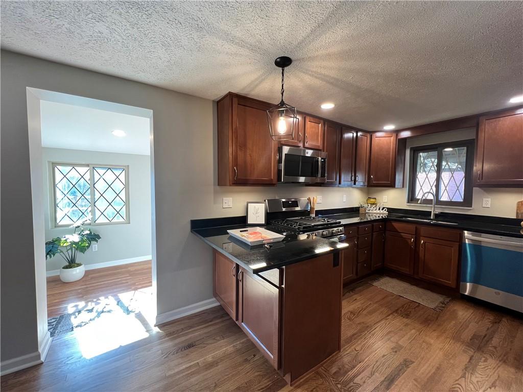 901 Greenhill Road Pittsburgh, PA 15209 - Photo 8 of 31 a kitchen with stainless steel appliances granite countertop wooden cabinets a sink a stove and a wooden floors